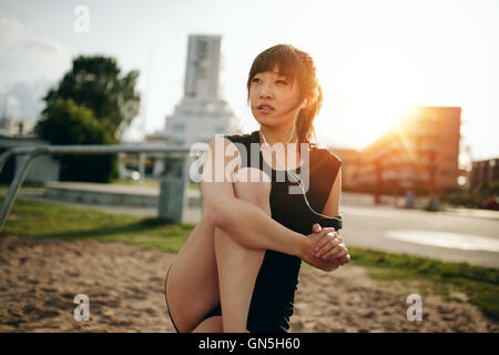 Giovane donna sana che si allunga la gamba dopo l'allenamento. fitness femminile rilassante dopo l'allenamento. Foto Stock