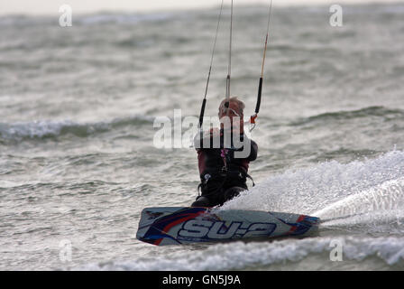 Fotografia di © Jamie Callister. 76 enne Kite surfer Paolo gode di onde a Llanddwyn Island, Anglesey, Galles del Nord. Foto Stock