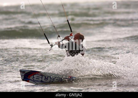 Fotografia di © Jamie Callister. 76 enne Kite surfer Paolo gode di onde a Llanddwyn Island, Anglesey, Galles del Nord. Foto Stock