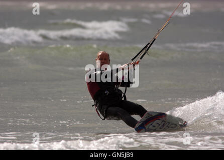 Fotografia di © Jamie Callister. 76 enne Kite surfer Paolo gode di onde a Llanddwyn Island, Anglesey, Galles del Nord. Foto Stock