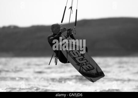 Fotografia di © Jamie Callister. 76 enne Kite surfer Paolo gode di onde a Llanddwyn Island, Anglesey, Galles del Nord. Foto Stock