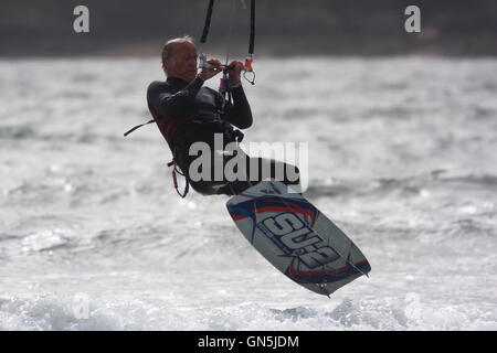 Fotografia di © Jamie Callister. 76 enne Kite surfer Paolo gode di onde a Llanddwyn Island, Anglesey, Galles del Nord. Foto Stock