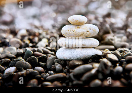 Piramide di pietre sulla spiaggia. Lo Zen e l'armonia del concetto. Foto Stock