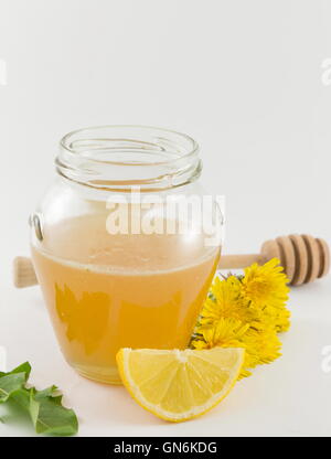 Un vasetto di miele, giallo tarassaco e limoni freschi Foto Stock