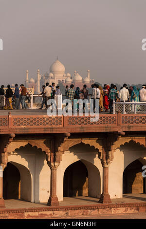 Visitatori ammirando la vista in lontananza il Taj Mahal dal monumento Mughal del XVI secolo conosciuto come il Forte Rosso di Agra in Agra Foto Stock