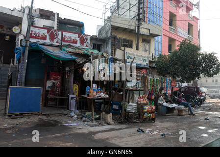 Una serie di negozi e bancarelle in una zona impoverita di Agra a Uttar Pradesh. India il cartello turistico per il Taj Mahal sul Foto Stock