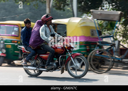 Tre su una motocicletta realizzato per due in sella ad Agra in Uttar Pradesh, India Foto Stock