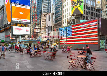 Le persone godono della sede della via pedonale plazas in Times Square inizio durante un weekend di mattina nella città di New York. Foto Stock