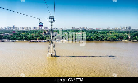 La funivia telecabina oltre il Fiume Songhua verso la sponda settentrionale, Sun Island e lo skyline di Songbei del distretto di Harbin Foto Stock