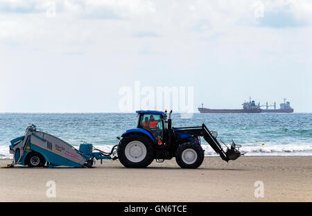 Servizio di manutenzione per le spiagge di Castellon de la Plana (Spagna). Il trattore traina una macchina aspirapolvere, BeachTech 2800 Foto Stock