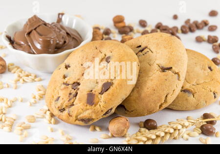 Biscotti con scaglie di cioccolato e crema di nocciole su bianco Foto Stock