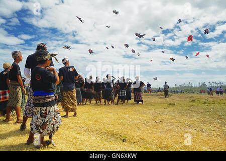 Sanur, isola di Bali, Indonesia - 15 Luglio 2012: Balinese non identificato gli uomini guardando il gruppo di coloratissimi aquiloni di grandi dimensioni che vola in cielo Foto Stock