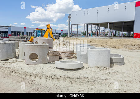 Il nuovo calcestruzzo tubi prefabbricati per pozzetto di drenaggio o impilati in cantiere. Foto Stock