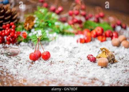 Bellissimo sfondo di Natale di apple, dadi, coni, bacche, abete e neve, primo piano Foto Stock