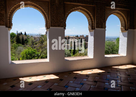 L' Alhambra Palace, Granada, Andalusia, visto attraverso gli archi in i giardini di Generalife Foto Stock