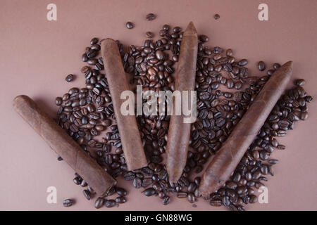 Sigari Cubani e i chicchi di caffè su sfondo marrone Foto Stock