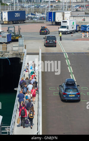 Passeggeri e auto sbarcare un traghetto per auto a Saint Peter Port Guernsey. Foto Stock