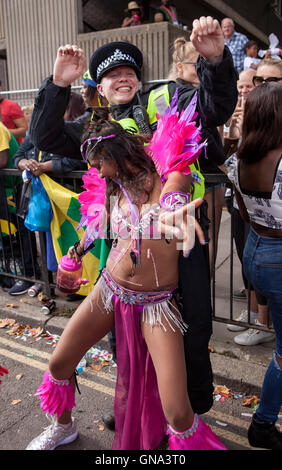 Londra, Regno Unito. 29 Agosto, 2016. Per i bambini, sfilata di carnevale di Notting Hill. Un uomo di polizia è intrappolato in danze con uno della sfilata interpreti per tutti divertimento e svago. Credito: Jane Campbell/Alamy Live News Foto Stock