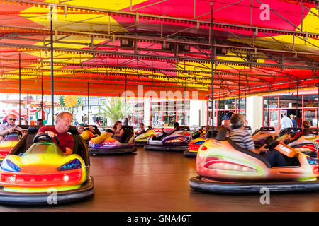 Dodgems, AKA autoscontro, venendo rinviato attorno ad adulti e bambini presso il lungomare a Ramsgate, Kent località di villeggiatura, in estate. Foto Stock