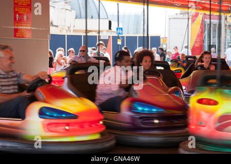 Inghilterra, Ramsgate. Dodgems. Le persone felici godendo di guida e di sterzata auto paraurti e schiantarsi in altri. Un sacco di motion blur. Foto Stock