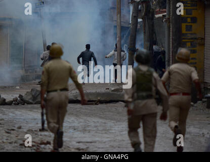 Srinagar Kashmir. 29 Agosto, 2016. La polizia indiana a caccia di contestatori del Kashmir mentre essi scagliare pietre durante una manifestazione di protesta a Srinagar, dopo il coprifuoco è stato sollevato in alcune parti di Indiano-Kashmir controllata, autorità lunedì sollevato il coprifuoco a più parti di Indiano-Kashmir controllata. La valle è bloccata per 52 giorno di oggi. Aziende e negozi sono rimaste chiuse per protestare contro la regola di indiani. Credito: Muzamil Mattoo/Alamy Live News Foto Stock