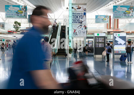 I viaggiatori a piedi passato a Tokyo Giochi Olimpici e Paraolimpici pubblicità su display a Tokyo International Airport il 30 agosto 2016, Tokyo, Giappone. Tra il 24 agosto e 10 ottobre l'aeroporto è la visualizzazione di molte Benvenuto a Tokyo 2020 indicazioni per promuovere il 2020 Giochi olimpici estivi. © Rodrigo Reyes Marin/AFLO/Alamy Live News Foto Stock