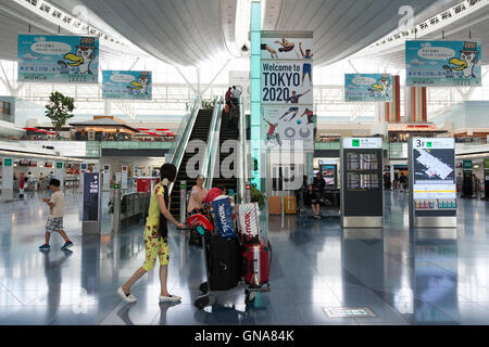 I viaggiatori a piedi passato a Tokyo Giochi Olimpici e Paraolimpici pubblicità su display a Tokyo International Airport il 30 agosto 2016, Tokyo, Giappone. Tra il 24 agosto e 10 ottobre l'aeroporto è la visualizzazione di molte Benvenuto a Tokyo 2020 indicazioni per promuovere il 2020 Giochi olimpici estivi. © Rodrigo Reyes Marin/AFLO/Alamy Live News Foto Stock