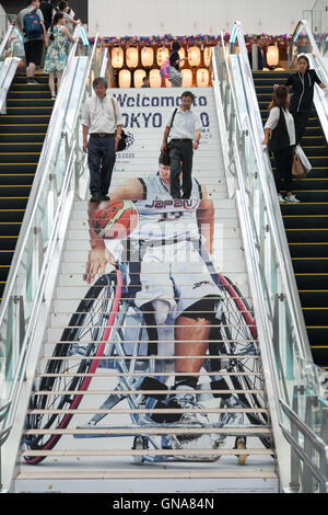 I viaggiatori a piedi passato a Tokyo Giochi Paralimpici pubblicità su display a Tokyo International Airport il 30 agosto 2016, Tokyo, Giappone. Tra il 24 agosto e 10 ottobre l'aeroporto è la visualizzazione di molte Benvenuto a Tokyo 2020 indicazioni per promuovere il 2020 Giochi olimpici estivi. © Rodrigo Reyes Marin/AFLO/Alamy Live News Foto Stock