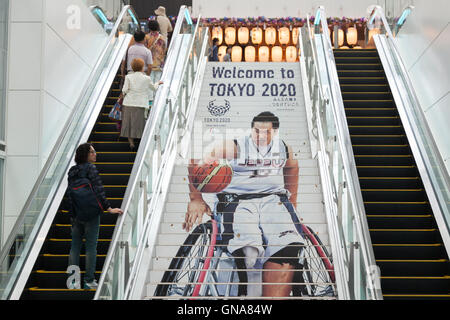 I viaggiatori a piedi passato a Tokyo Giochi Paralimpici pubblicità su display a Tokyo International Airport il 30 agosto 2016, Tokyo, Giappone. Tra il 24 agosto e 10 ottobre l'aeroporto è la visualizzazione di molte Benvenuto a Tokyo 2020 indicazioni per promuovere il 2020 Giochi olimpici estivi. © Rodrigo Reyes Marin/AFLO/Alamy Live News Foto Stock