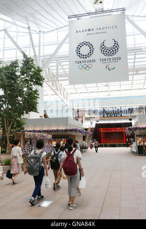 I viaggiatori a piedi passato a Tokyo Giochi Olimpici e Paraolimpici pubblicità su display a Tokyo International Airport il 30 agosto 2016, Tokyo, Giappone. Tra il 24 agosto e 10 ottobre l'aeroporto è la visualizzazione di molte Benvenuto a Tokyo 2020 indicazioni per promuovere il 2020 Giochi olimpici estivi. © Rodrigo Reyes Marin/AFLO/Alamy Live News Foto Stock