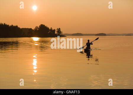 Paddle-imbarco sul lago durante il tramonto Foto Stock