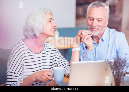 Amorevole positivo coppia senior in appoggio nel cafe Foto Stock