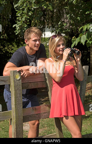 Matura nella campagna dell'Hampshire England Regno Unito - una giovane coppia con un paio di binocoli nella campagna inglese Foto Stock