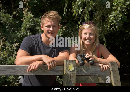 Matura nella campagna dell'Hampshire England Regno Unito - una giovane coppia con un paio di binocoli nella campagna inglese Foto Stock