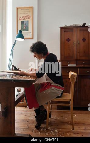 La foresta dei violini, Paneveggio, Italia. Giovanna Chittò, liutaio (liutaio), utilizzando un piano di legno di forma per un violoncello nella sua officina Foto Stock