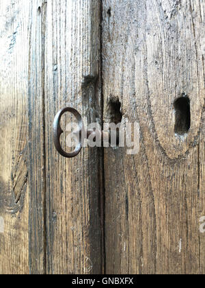 Si tratta di una foto di un vecchio tipo di chiave in una serratura di una vecchia porta di legno in Normandia Foto Stock