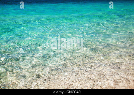 Acqua di mare superficie con ghiaia costiere al di sotto di esso, foto di sfondo texture Foto Stock