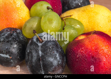 Varie carni bio di prugne, pesche noci, uva e pere sul tavolo di legno Foto Stock