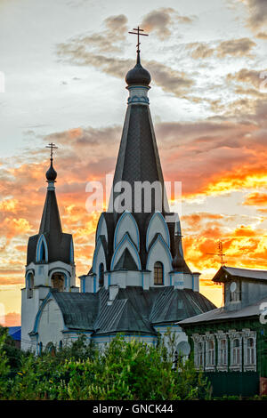 Vecchia chiesa oltre la masterizzazione tramonto nel villaggio russo Foto Stock