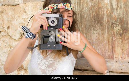 Ragazza con fotocamera vintage su una vecchia strada Foto Stock