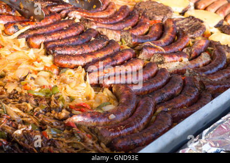 La grigliatura grande succosa salsiccia con le cipolle e i peperoni per barbecue estivi Foto Stock