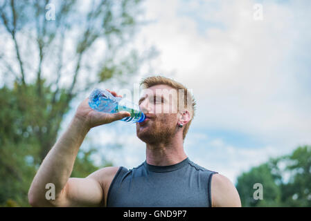 Sport atletici uomo acqua potabile da una bottiglia Foto Stock