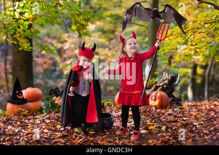 Due bambini divertenti indossando devil e vampire costume rosso con corna e trident trucco o trattamento di Halloween. Foto Stock