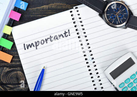 Importante testo su notepad e guarda sulla scrivania Foto Stock