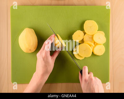 Affettare le mani potatoe utilizzato su scheda in plastica Foto Stock