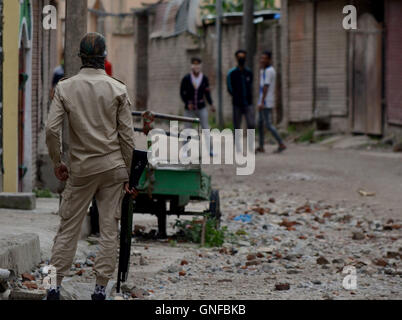 Il Kashmir. Il 30 agosto, 2016. Un indiano poliziotti tenendo un azione pompa pistola a pellet come egli guarda verso i manifestanti in Srinagar, controllata indiana del Kashmir. Credito: Muzamil Mattoo/Alamy Live News Foto Stock