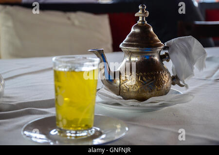 Marocchino tradizionale tè alla menta servito da autentica teiera di rame. Messa a fuoco selettiva Foto Stock