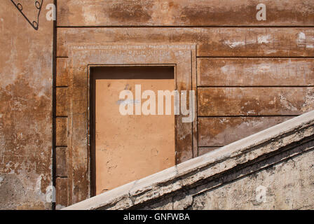 Tipico color terracotta degli edifici in italiano Roma. I dettagli di una architettura, toccato da tempo. Finestra decorativo. Foto Stock