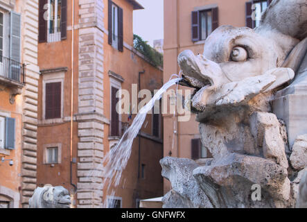 Uno dei romani belle fontane. Questo è situato nella parte anteriore del famoso Pantheon. Facce barocco e pesci. Foto Stock