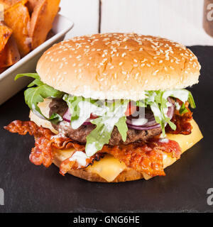 Gourmet home realizzati bacon cheeseburger su rustiche sfondi in legno Foto Stock